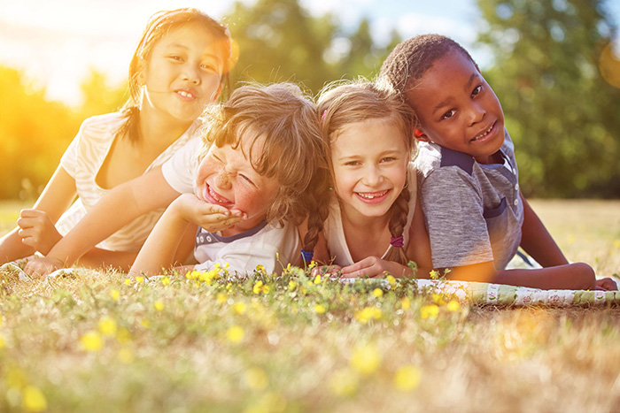 Das Foto zeigt vier liegende Kinder.